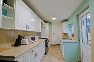 a kitchen with white cabinets and a microwave at Elevate suites Darlington in Darlington