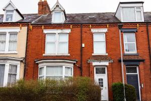 a red brick house with white windows and a black door at Elevate suites Darlington in Darlington