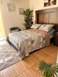 a bedroom with a bed and a wooden floor at Apartamento con alberca cerca de la playa in Manzanillo