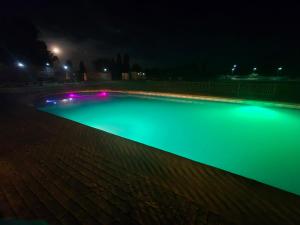 a swimming pool with green illumination at night at Cabañas y tinajas Filkun in Vilcún +8 photos