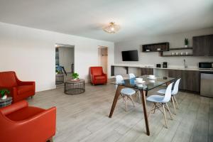 a living room with a table and chairs and a kitchen at Waterside Hotel and Suites in Miami Beach