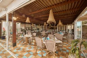 a restaurant with tables and chairs in a room at Hotel Argos Ibiza in Talamanca