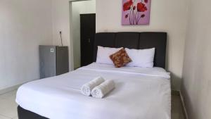 a white bed with two rolled towels on it at Saphala Suites Secondfloor in Seminyak