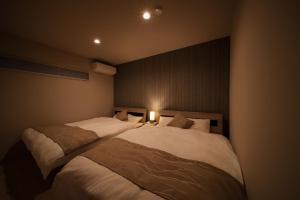 a bedroom with two beds and a light on the wall at 湯宿灯火 in Beppu +17 photos
