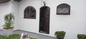 two windows and a door on a white building at Pousada Ruby in Irati +4 photos