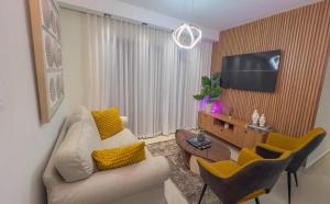 a living room with a couch and a flat screen tv at San Isidro Urban suite in Juan López