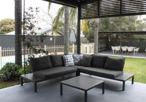 a couch and a coffee table on a patio at Lunar Cabins in Parkes