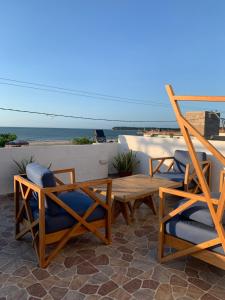 a patio with chairs and a table and the ocean at Hostel La Catalina Plus - frente al mar in Cartagena de Indias
