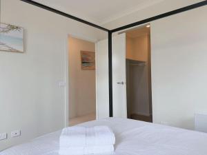 a bedroom with a white bed and a mirror at Modern Home Canal Berwick in Berwick