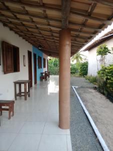 a porch with a column and benches in a building at Mami Wata Pousada do Mar in Massarandupio