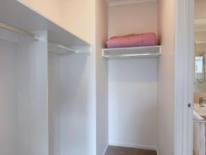 a walk in closet with white walls and a shelf at Modern Home Canal Berwick in Berwick +22 photos