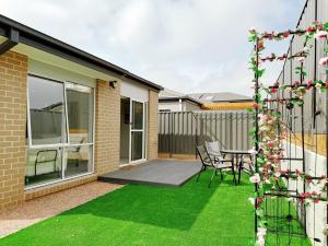 a patio with a table and chairs on a lawn at Modern Home Canal Berwick in Berwick