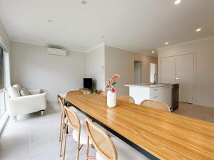 a living room with a long wooden table and chairs at Modern Home Canal Berwick in Berwick