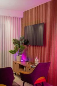 a living room with a tv on a red wall at San Isidro Urban suite in Juan López