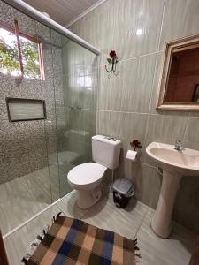 a bathroom with a toilet and a shower and a sink at Pousada Chalés Vida Verde in Bom Jardim de Minas +45 photos