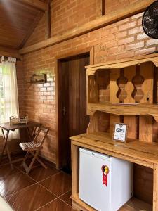 a kitchen in a wooden cabin with a refrigerator at Pousada Chalés Vida Verde in Bom Jardim de Minas