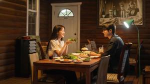 a man and a woman sitting at a table eating food at Gapyeong Solle Spa Pension in Gapyeong