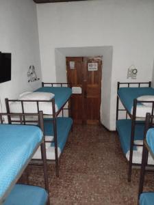 a room with three blue bunk beds and a door at Feathers Hotel & Lounge in Antigua Guatemala