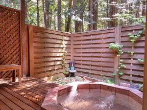 a wooden privacy fence with a hot tub on a deck at Lumiere in Fujikawaguchiko