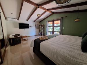 a bedroom with a large bed and a television at Olla é Mono Ecolodge in Sarapiquí