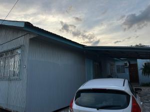 a white car parked next to a building at Cantinho do Descanso in Cascavel