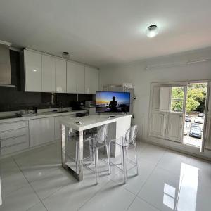 a kitchen with white cabinets and a table and chairs at Lindo studio no Residencial Quisisana in Poços de Caldas