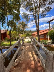 a wooden bridge in front of a building at Pousada Chalés Vida Verde in Bom Jardim de Minas