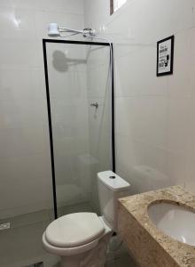 a bathroom with a toilet and a shower and a sink at Cantinho do Descanso in Cascavel +6 photos