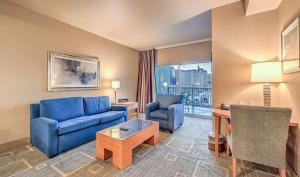 a living room with a blue couch and chairs and a desk at The Platinum Hotel Las Vegas in Las Vegas