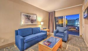 a living room with two blue couches and a window at The Platinum Hotel Las Vegas in Las Vegas