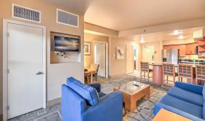 a living room with blue couches and a kitchen at The Platinum Hotel Las Vegas in Las Vegas