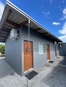 a house with a door and a television on the side at Mini Casa 5 in Itajaí