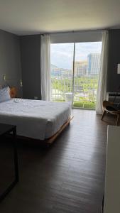 a bedroom with a bed and a large window at Inn on The Park in Honolulu +8 photos