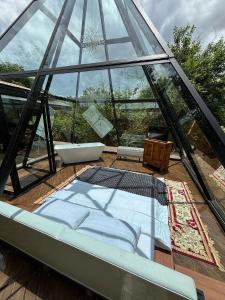 a glass house with a bed in the middle at Piramidevidro in Santa Isabel