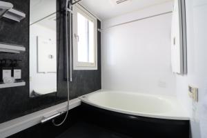 a bathroom with a tub and a glass shower at Yokohama Mega Stay in Yokohama
