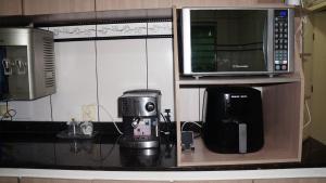 a kitchen counter with a coffee maker and a microwave at Casa compartilhada com Quarto e Suite no Parque 10 in Manaus