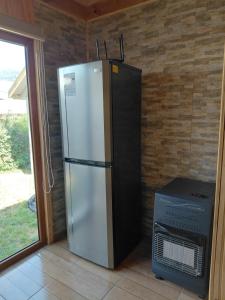 a refrigerator and a microwave in a room at Los Gladiolos in Melipeuco