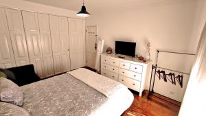 a bedroom with a bed and a tv on a dresser at DockApartment in Vila Nova de Gaia