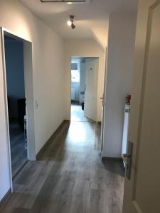 an empty hallway of an apartment with a hard wood floor at P.T-Pension in Oldenburg