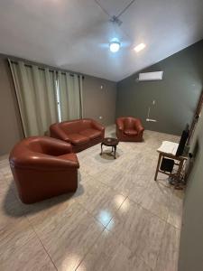 a living room with two leather couches and a table at Kusi 51 in La Banda