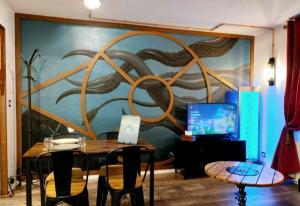 a room with a table and a wall with a mural at DiscoveryHome 4Pers Disneyland Paris à 10 min bus, Free Parking, Outlet Shopping, Village Nature in Magny-le-Hongre +24 photos