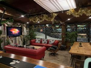 a living room with red couches and a tv at Ski-in, Ski-out Iwatake Apartments in Hakuba