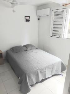 a bedroom with a bed in a white room at Abricotier à proximité des plages du sud in Rivière-Pilote