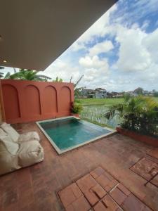 a swimming pool in the middle of a patio at Buduk villa in Dalung
