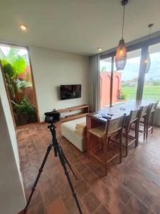a camera on a tripod in a room with a table and chairs at Buduk villa in Dalung