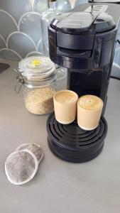 a coffee maker sitting on a counter with two cups of coffee at Villa Bois coco Les Saintes in Terre-de-Haut