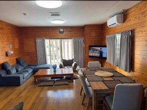 a living room with a table and a dining room at 2 Peaks Snow Lodge in Hakuba