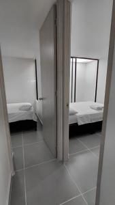 a room with two beds and a open door at Denier House Fuente de los Rosales - A 5 minutos de Centros Comerciales in Ibagué