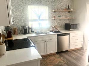 a kitchen with white cabinets and a sink and a microwave at Horizon Haven in Jacksonville