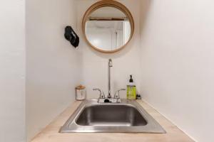 a kitchen sink with a mirror on the wall at Brews, Bites, & Pines - Your downtown Flagstaff suite in Flagstaff +26 photos